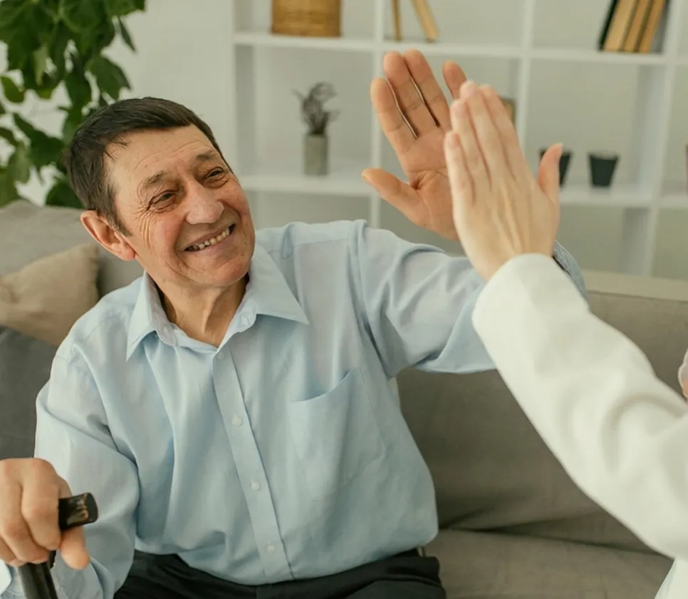 A happy patient high-fiving his dentist, pleased with his treatment